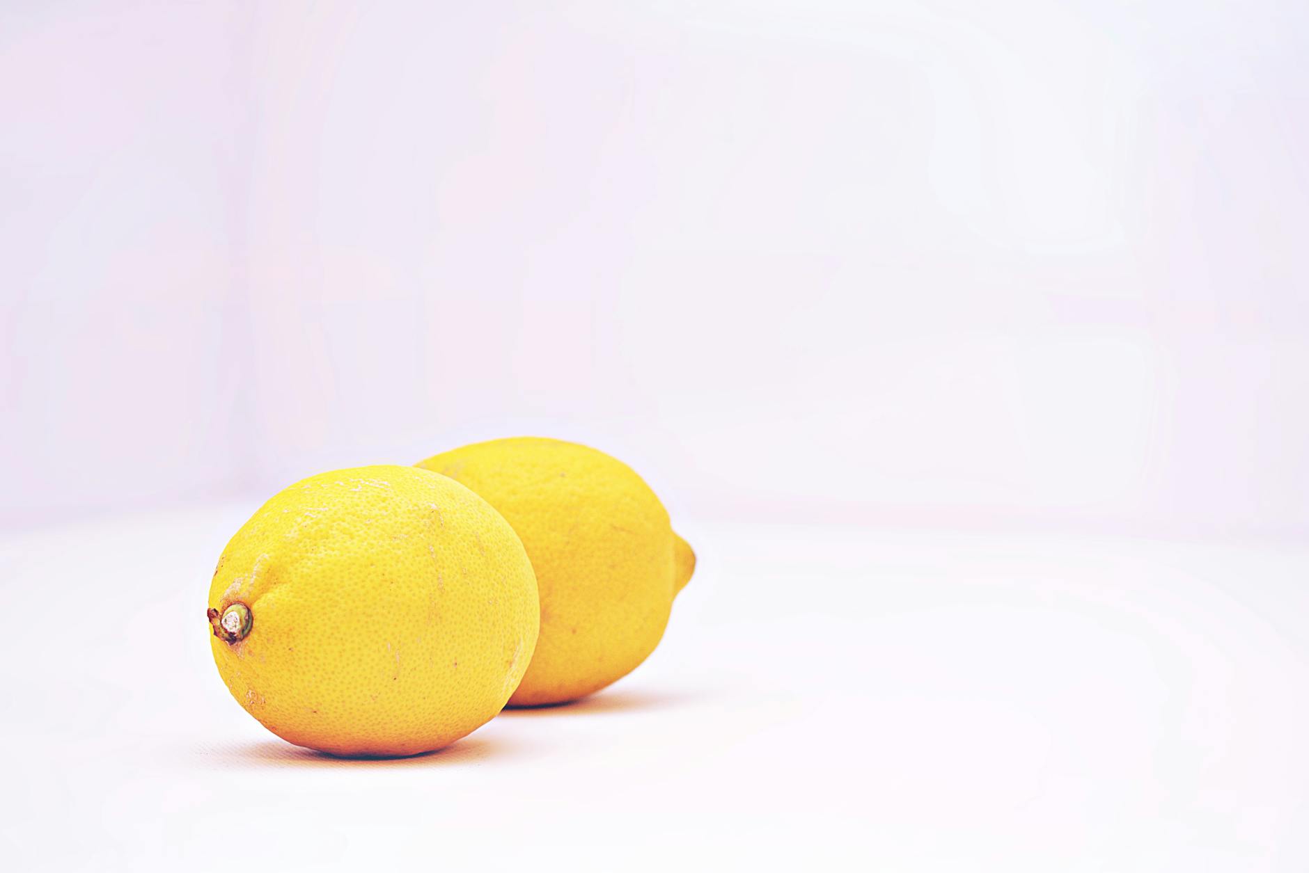 Two vibrant fresh lemons on a minimalist white background, symbolizing clarity and simplicity in choosing the right toy