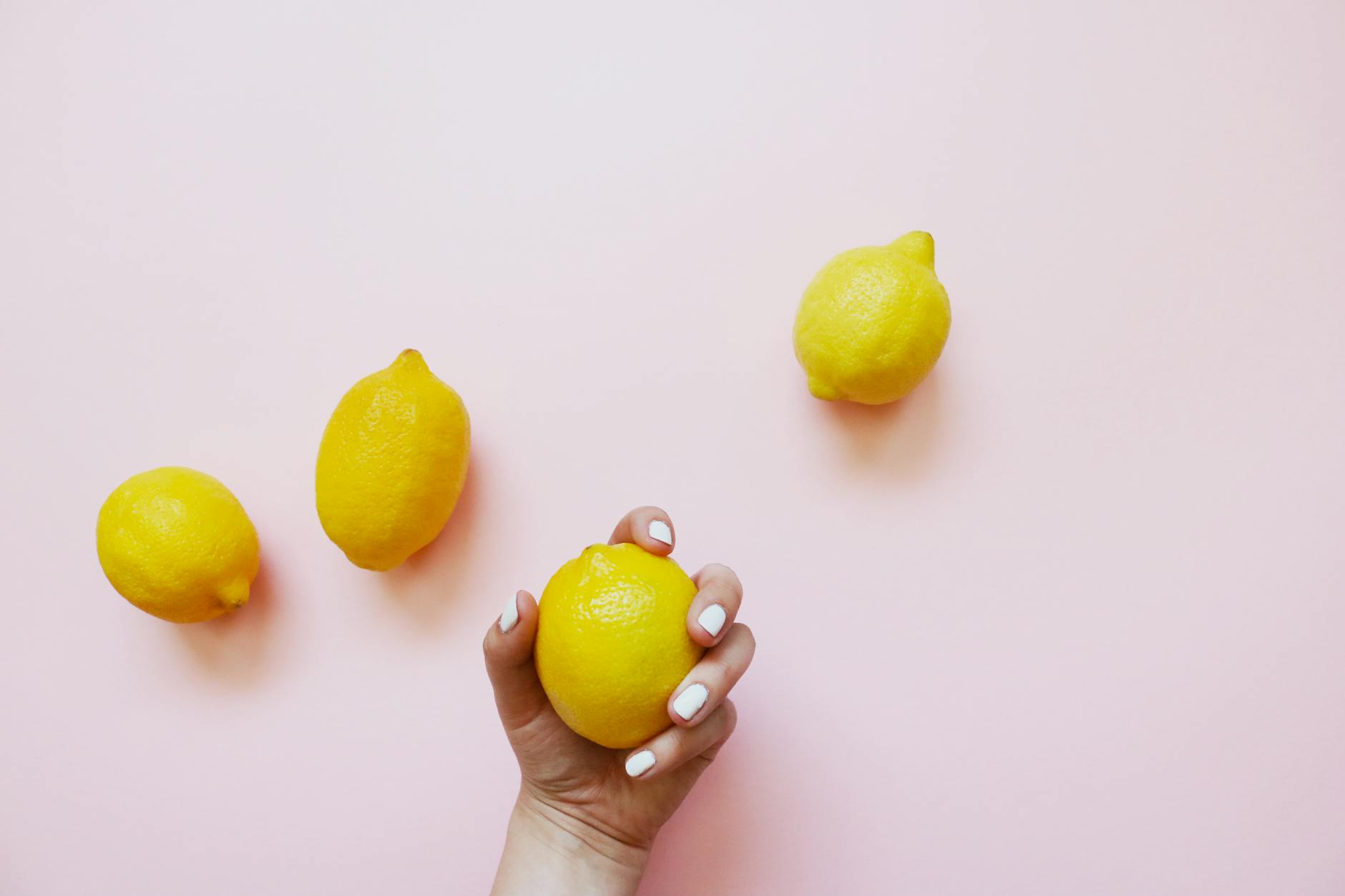 A hand holding an orange vibrator against a purple backdrop, showcasing sensuality and modern intimacy.