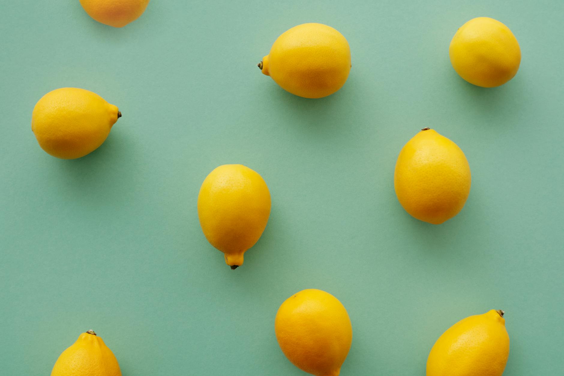 Bright yellow lemons arranged on a pastel green background, symbolizing fresh approaches to intimate pleasure