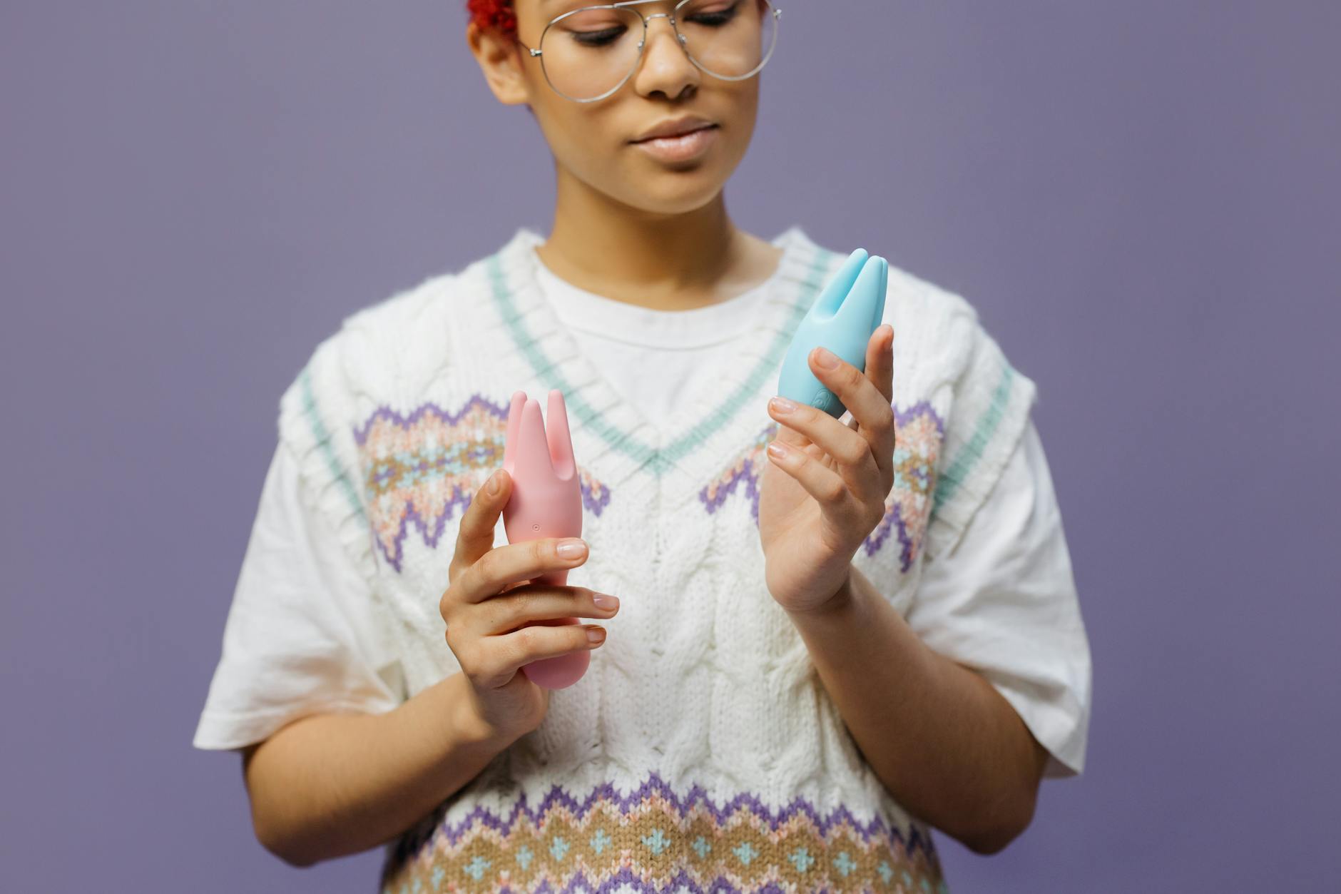 Woman holding a blue silicone clitoral vibrator, exploring sensation and pleasure during hormonal changes.
