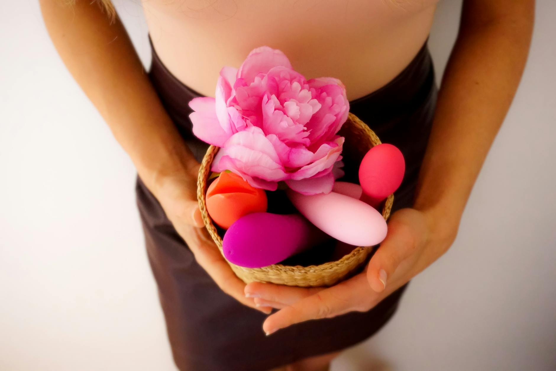 Hand holding a vibrator against a minimalistic backdrop, symbolizing modern intimacy tools for reconnection