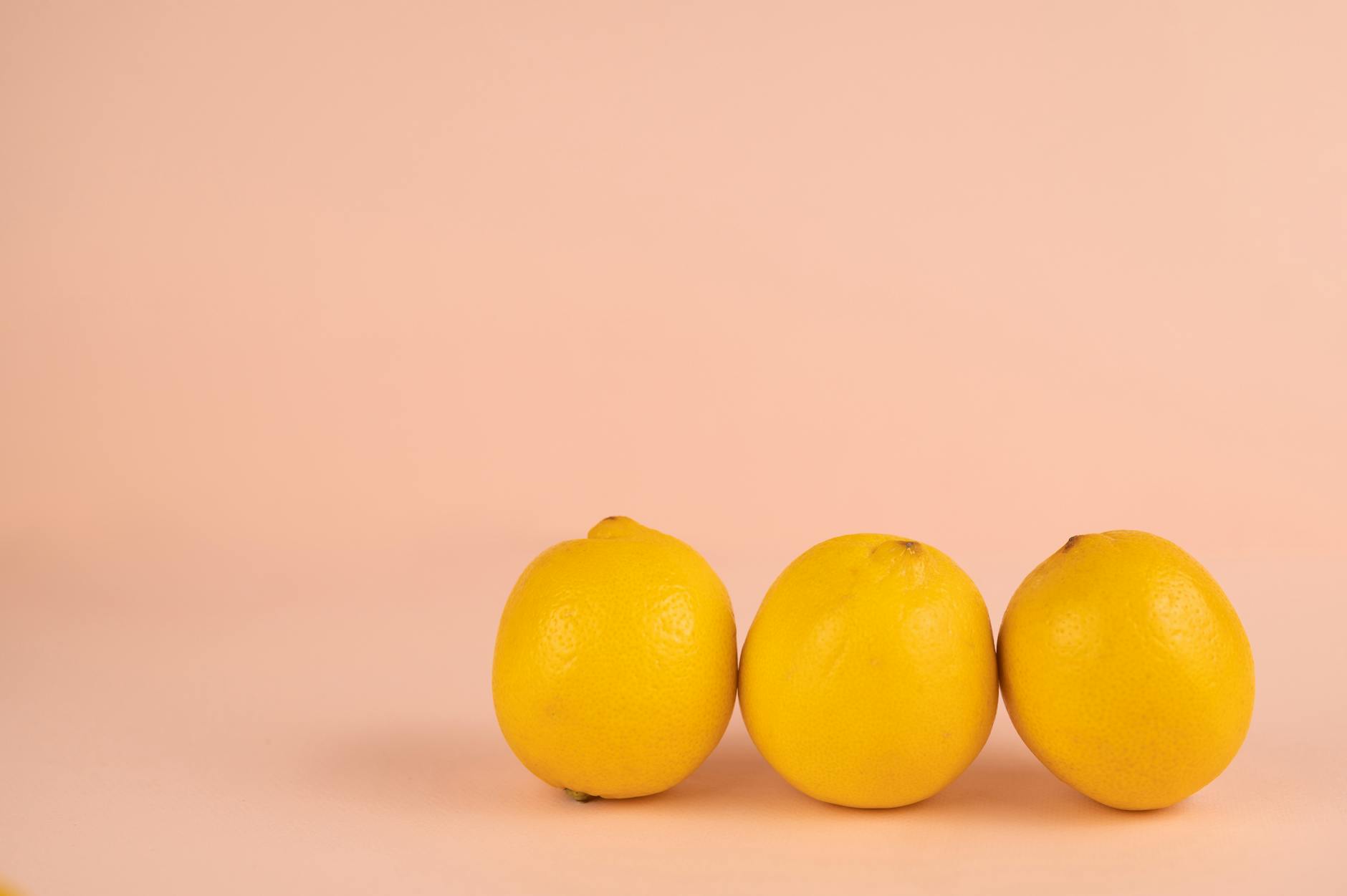 Hand holding an orange vibrator against a minimalistic purple backdrop, showcasing modern sensuality